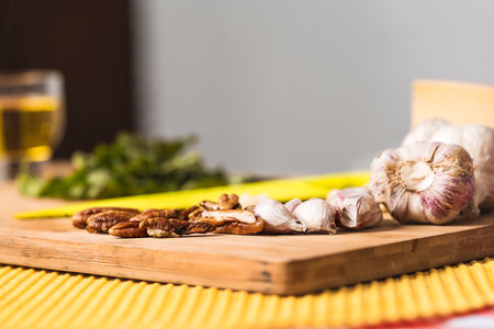 Low angle view of nuts and garlic on a wooden board for preparing a pesto sauce.の写真素材