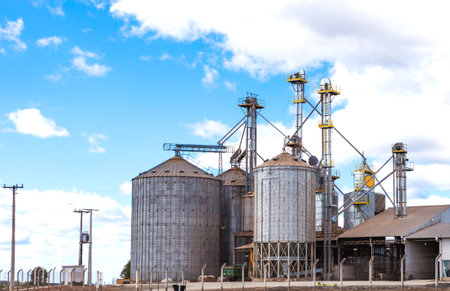 Rural area with grain storage silos and blue sky with clouds.の写真素材