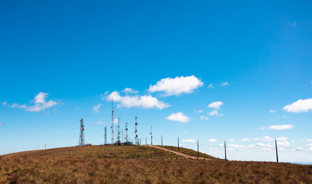Blue sky and hill with telecommunication antennas.の写真素材