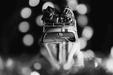 Black and white image old car with christmas presents on the roof rack dreamy soft focused bokeh ballsの写真素材