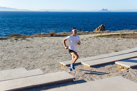 Young caucasian man exercising in the park running up on stairsの写真素材