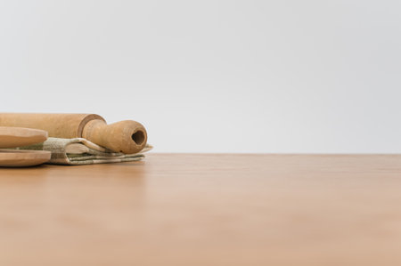 natural wood kitchen utensils and a table napkin on a wooden background with copy spaceの写真素材