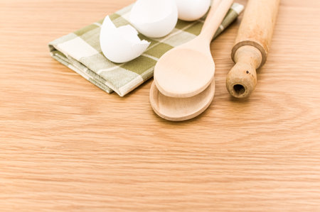 natural wood kitchen utensils and a table napkin on a wooden background with copy space