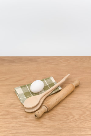 natural wood kitchen utensils and a table napkin on a wooden background with copy spaceの写真素材