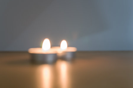 row of white scented wax tea lights on a wooden tabletop with copy spaceの写真素材