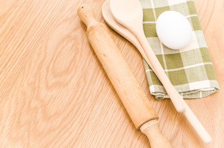 natural wood kitchen utensils and a table napkin on a wooden background with copy spaceの写真素材