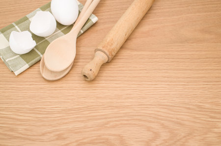 natural wood kitchen utensils and a table napkin on a wooden background with copy spaceの写真素材