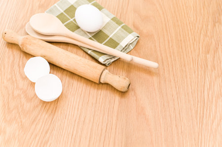natural wood kitchen utensils and a table napkin on a wooden background with copy space