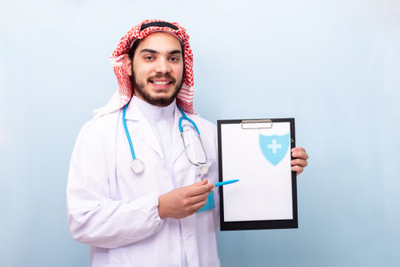 Arabian muslim man doctor with beard and traditional outfit, with clipboard.の写真素材