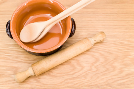 natural terracotta bowl and wood kitchen utensils on a wooden background with copy spaceの写真素材