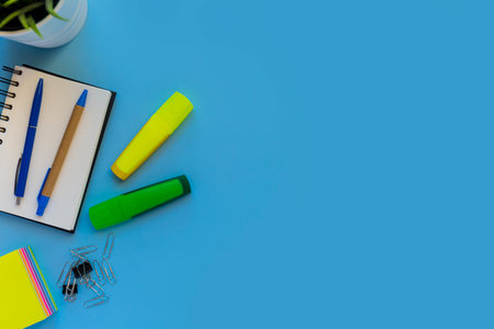 Flat lay workspace, copy space, blue background, top view office desk