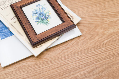 images and posters in glass clip frames on a wooden surface with copy space