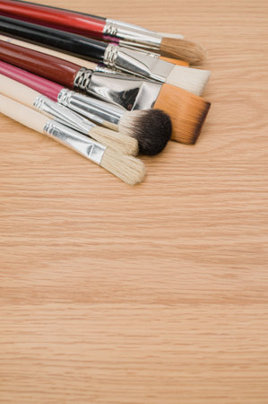 set of paintbrushes on a wooden tabletop with copy spaceの写真素材