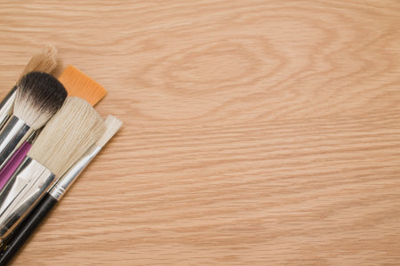 set of paintbrushes on a wooden tabletop with copy spaceの写真素材