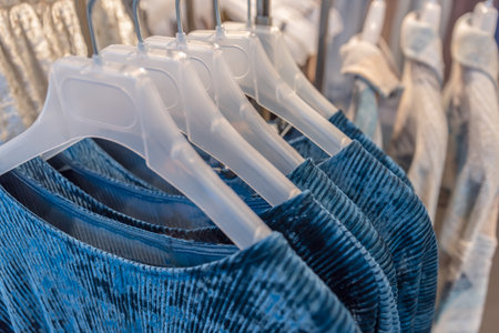 Clothes hanging on the hangers of the clothing boutique with selective approachの写真素材