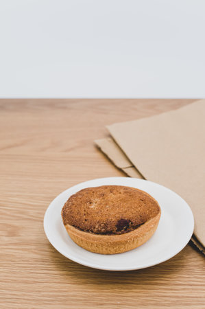 bio organic vegan tart in a white plate on a wooden tabletopの写真素材