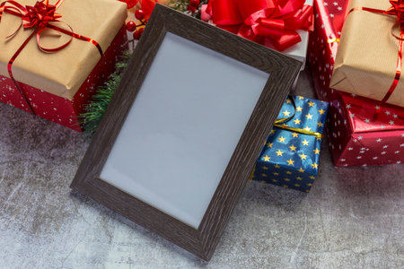 Blank wooden frame, Christmas gifts in the backgroundの写真素材