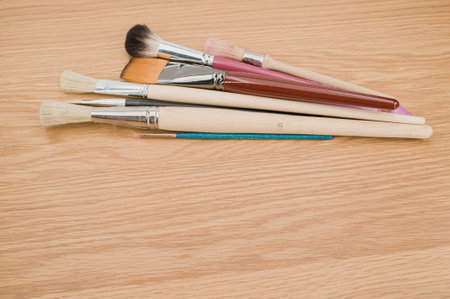 set of paintbrushes on a wooden tabletop with copy spaceの写真素材