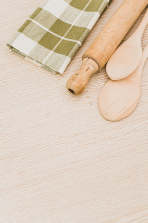 natural wood kitchen utensils and a table napkin on a wooden background with copy space
