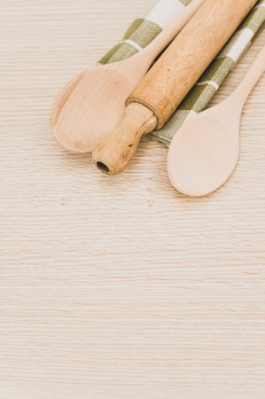 natural wood kitchen utensils and a table napkin on a wooden background with copy spaceの写真素材