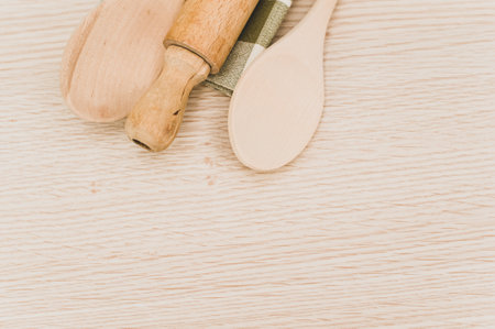 natural wood kitchen utensils and a table napkin on a wooden background with copy spaceの写真素材