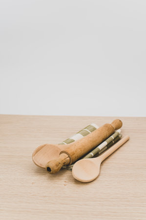 natural wood kitchen utensils and a table napkin on a wooden background with copy spaceの写真素材