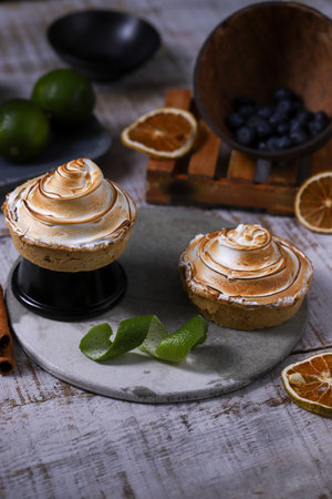 two pieces of lemon pie garnished with slices of lemon, orange and cranberriesの写真素材