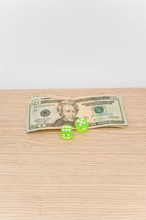 US dollar currency banknotes and dice on a wooden background with copy spaceの写真素材