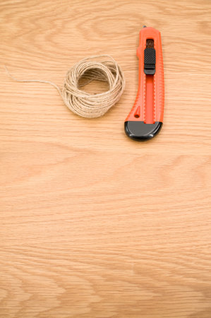 decorative cord and orange cutter on a wooden worktop with text spaceの写真素材