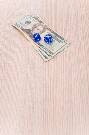 US dollar currency banknotes and dice on a wooden background with copy spaceの写真素材
