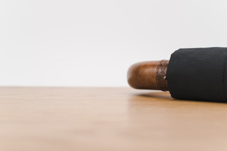 black foldable umbrella with solid wood handle on a wooden surface with copy spaceの写真素材
