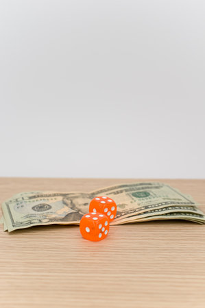 US dollar currency banknotes and dice on a wooden background with copy spaceの写真素材