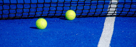 Two balls by the net of a paddle tennis courtの写真素材