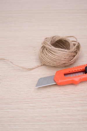 decorative cord and orange cutter on a wooden worktop with text space