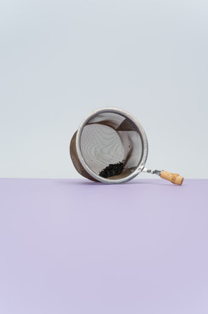 metal tea strainer on a lilac tabletop background with text spaceの写真素材