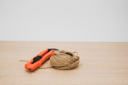 decorative cord and orange cutter on a wooden worktop with text space