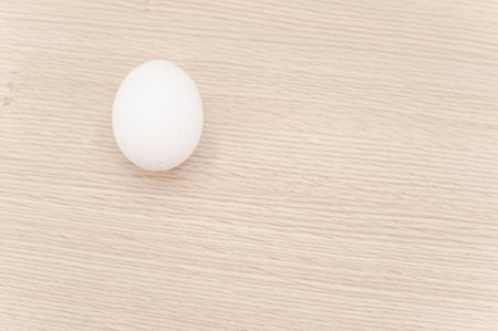 organic white eggs on a natural wooden tabletop surface with copy space for textの写真素材