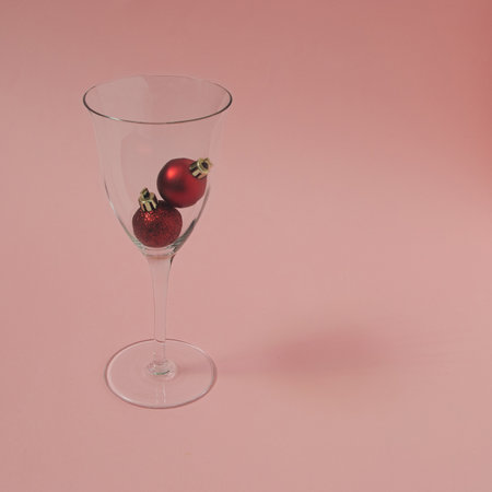 Wine glass with two New Year's red decorations in themの写真素材