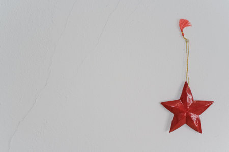 decorative red wooden star hanging on a white wallの写真素材