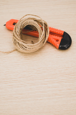 decorative cord and orange cutter on a wooden worktop with text space