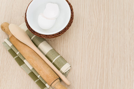 natural wood kitchen utensils and a table napkin on a wooden background with copy spaceの写真素材