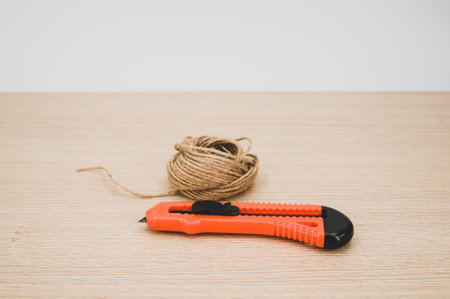 decorative cord and orange cutter on a wooden worktop with text space