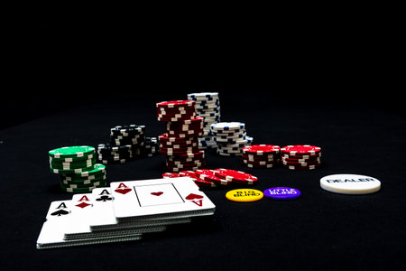 Stack of poker chips and poker cards on black background