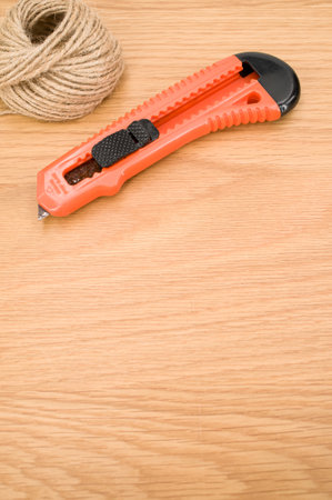 decorative cord and orange cutter on a wooden worktop with text spaceの写真素材