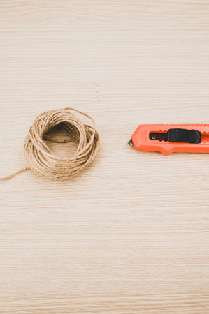 decorative cord and orange cutter on a wooden worktop with text spaceの写真素材