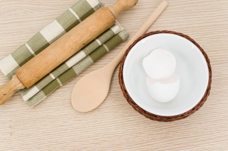 natural wood kitchen utensils and a table napkin on a wooden background with copy space