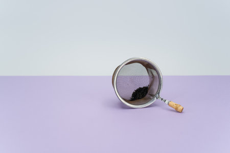 metal tea strainer on a lilac tabletop background with text spaceの写真素材