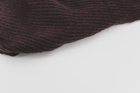 isolated dark brown knitted cloth on a white tabletop with text space