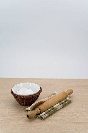 natural wood kitchen utensils and a table napkin on a wooden background with copy space