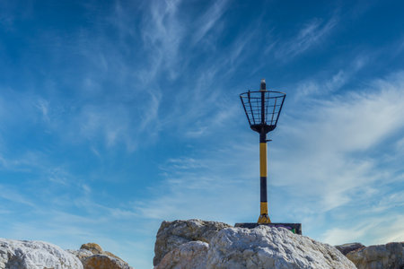 old lighthouse on the jetty notice for boatsの写真素材